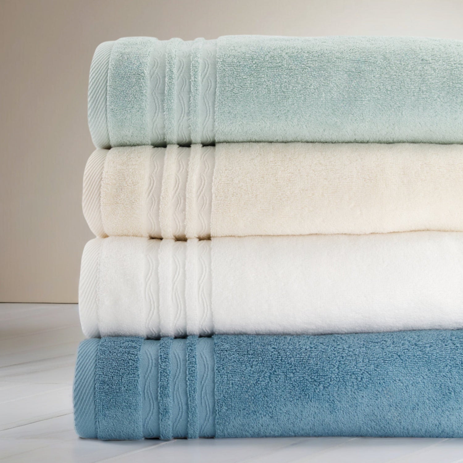 Serviettes de bain FLAMARDA Collection Signature Océan empilées par couleur, design haut de gamme inspiré des vagues portugaises