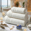 Sets de bain FLAMARDA composés de serviettes, draps et tapis de bain haut de gamme, présentés dans une salle de bain lumineuse avec vue sur l’océan