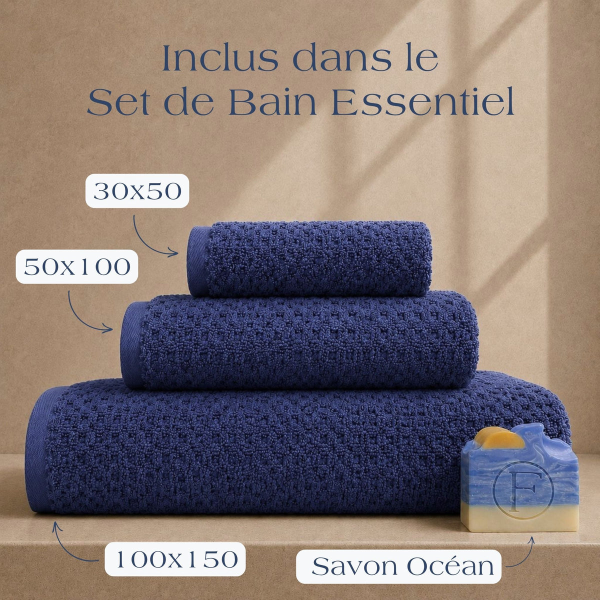 Set de Bain Essentiel FLAMARDA Prestige Dune Bleu Profond comprenant un drap de bain 100x150cm, une serviette 50x100cm, une serviette invité 30x50cm et un savon artisanal Océan, mis en scène dans un univers haut de gamme.