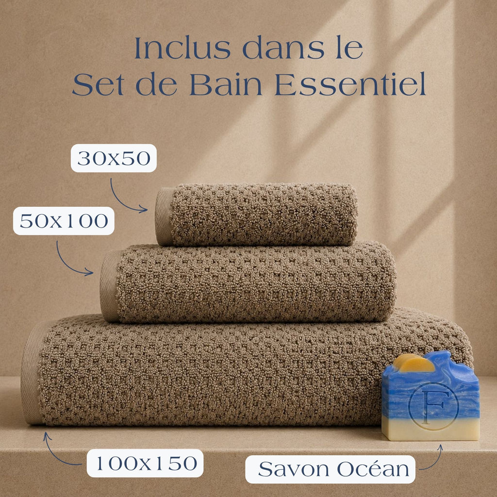 Set de Bain Essentiel FLAMARDA Prestige Dune Sable Brun comprenant un drap de bain 100x150cm, une serviette 50x100cm, une serviette invité 30x50cm et un savon artisanal Océan, dans des teintes naturelles et chaleureuses.