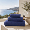 Serviettes de bain Prestige Dune Bleu Profond en coton peigné dans une salle de bain haut de gamme avec vue sur l'océan
