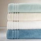 Serviettes de bain FLAMARDA Collection Signature Océan empilées par couleur, design haut de gamme inspiré des vagues portugaises