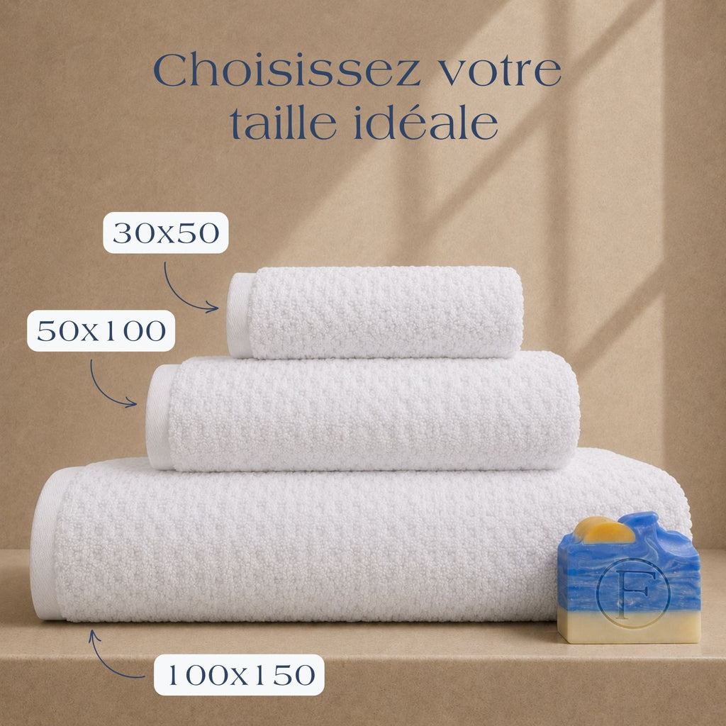 Guide des tailles FLAMARDA Prestige Dune Blanc Nacre présentant les dimensions 30x50cm, 50x100cm et 100x150cm. Serviettes de bain haut de gamme en coton peigné 600 g/m² dans une teinte blanc nacre lumineuse et intemporelle.