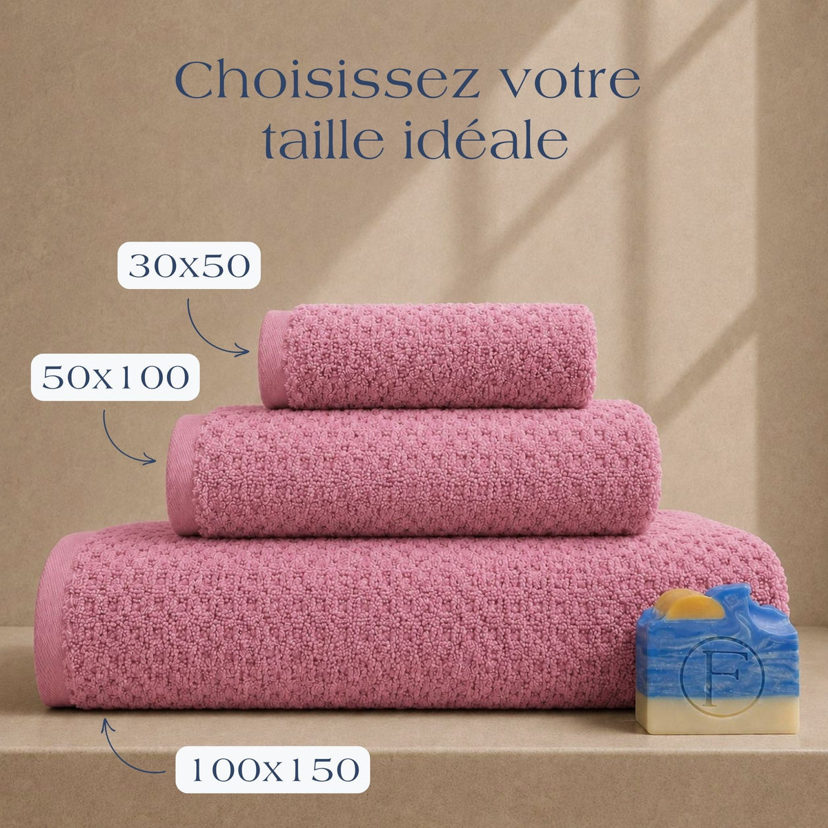 Guide des tailles FLAMARDA Prestige Dune Rose Brume présentant les dimensions 30x50cm, 50x100cm et 100x150cm. Serviettes de bain haut de gamme en coton peigné 600 g/m² dans une teinte rose douce et élégante.