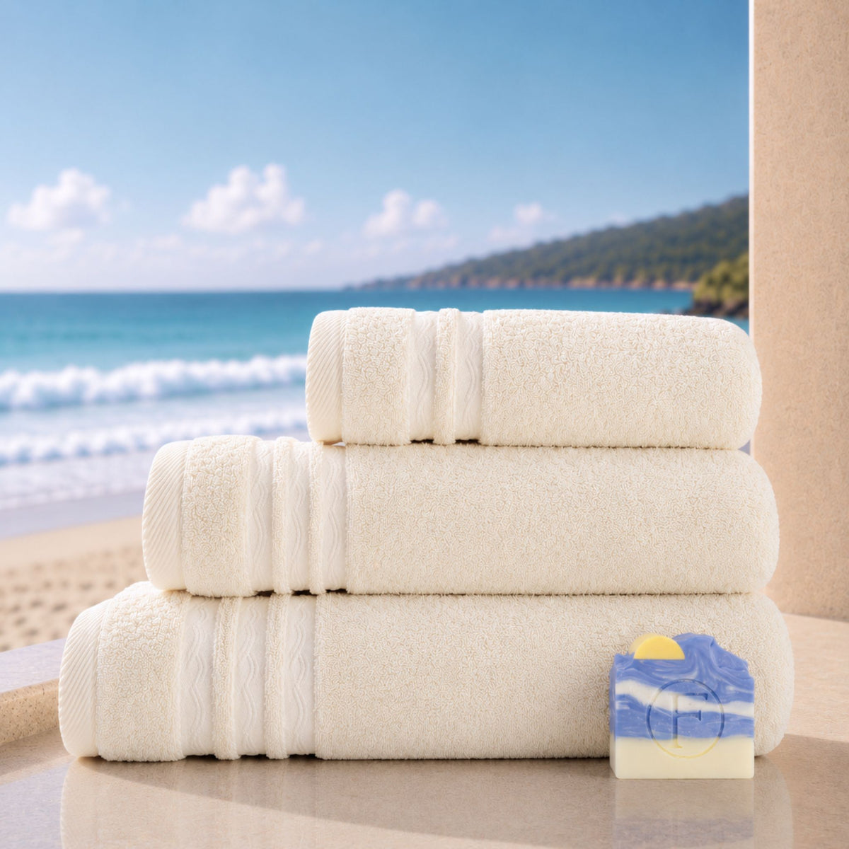 Set de Bain Essentiel Signature Océan Sable Naturel FLAMARDA avec un grand drap de bain 100x150cm, un drap de bain 70x140cm, une serviette de toilette 50x100cm et un savon artisanal Océan.